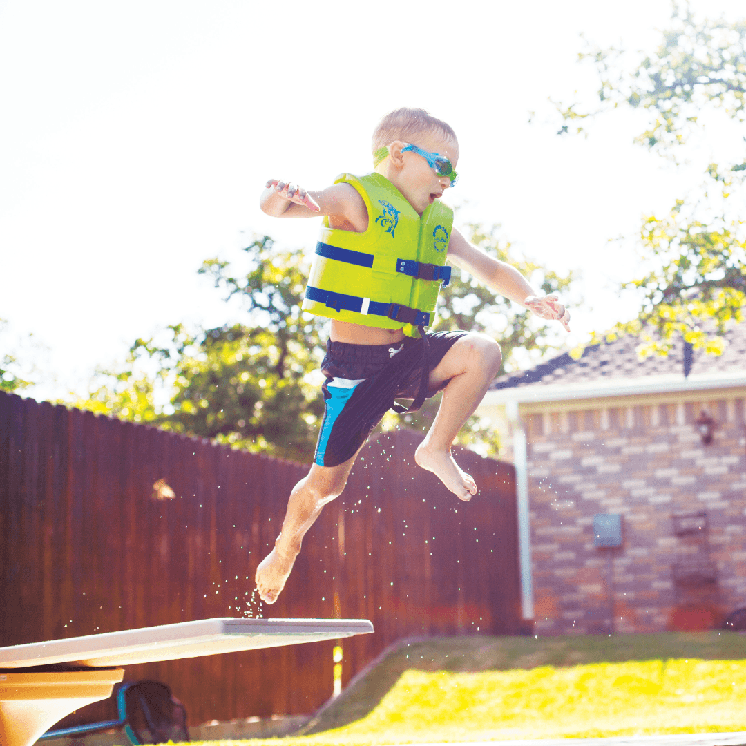 Child jumping into a pool wearing a green CPI Amusement life jacket
